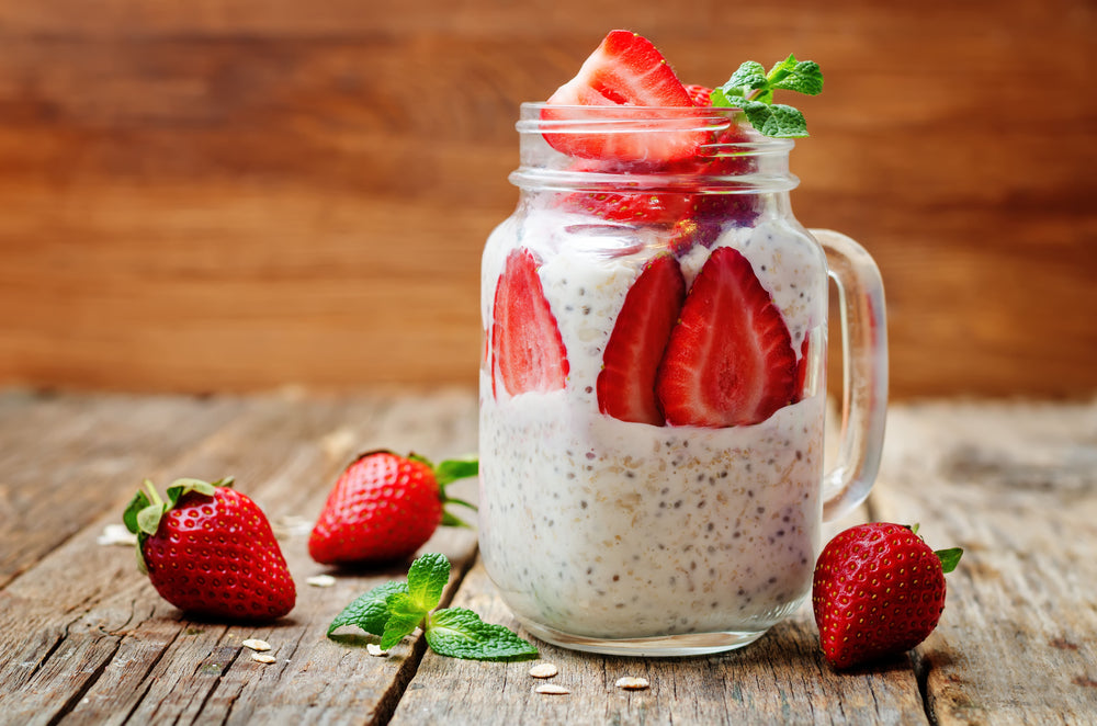 A glass jar filled with chia pudding topped with strawberries and mint